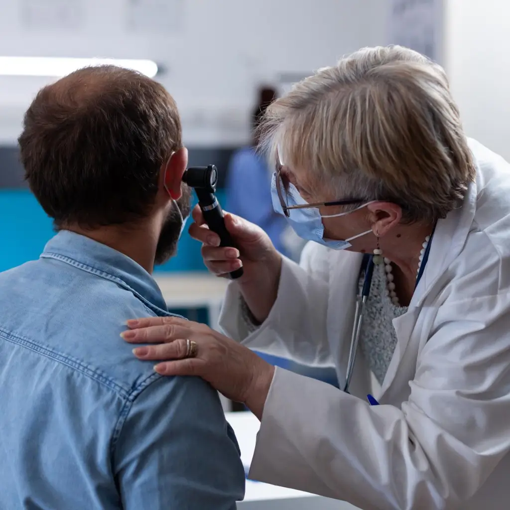 ENT doctor examining patient for unilateral tinnitus diagnosis